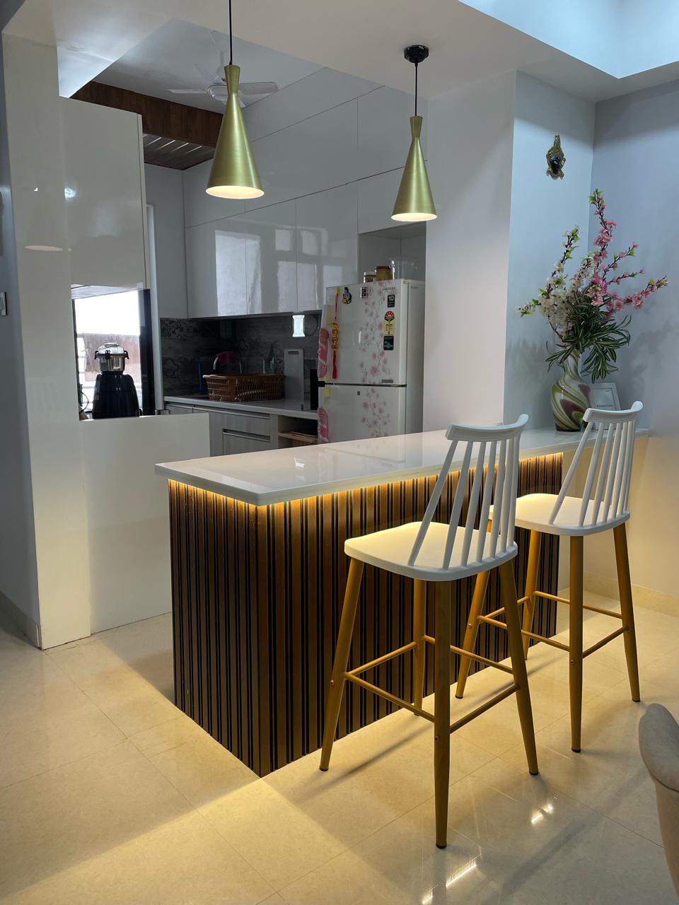 Modern Elegance: A sleek kitchen design featuring a stylish island with under-counter lighting, sophisticated white cabinetry, and contemporary bar stools. Perfectly blending functionality with a touch of luxury.